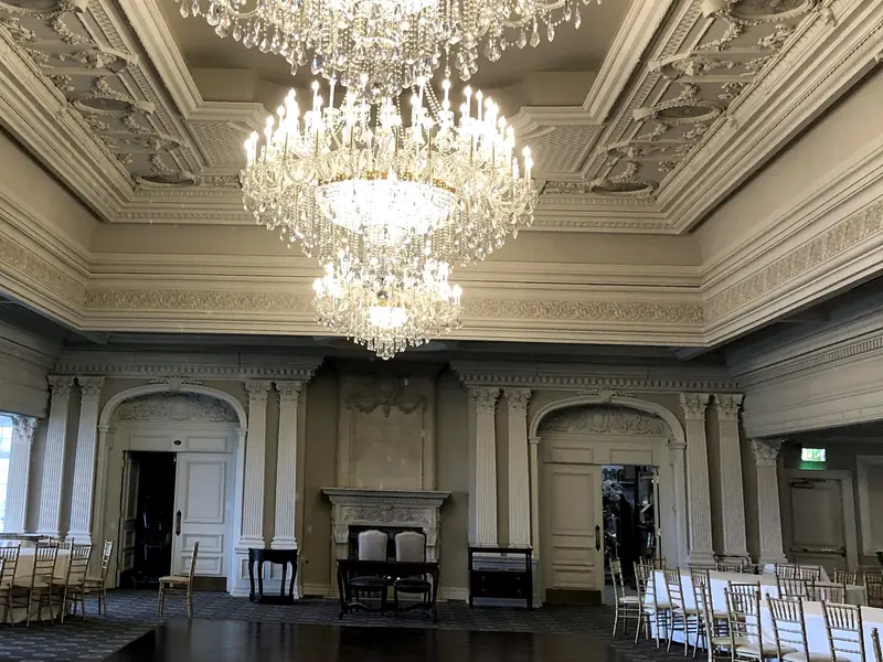 Park Savoy Ballroom, Florham Park, NJ: three tiered crystal chandeliers under an ornate plaster ceiling, with tables set in white cloths and gold chairs