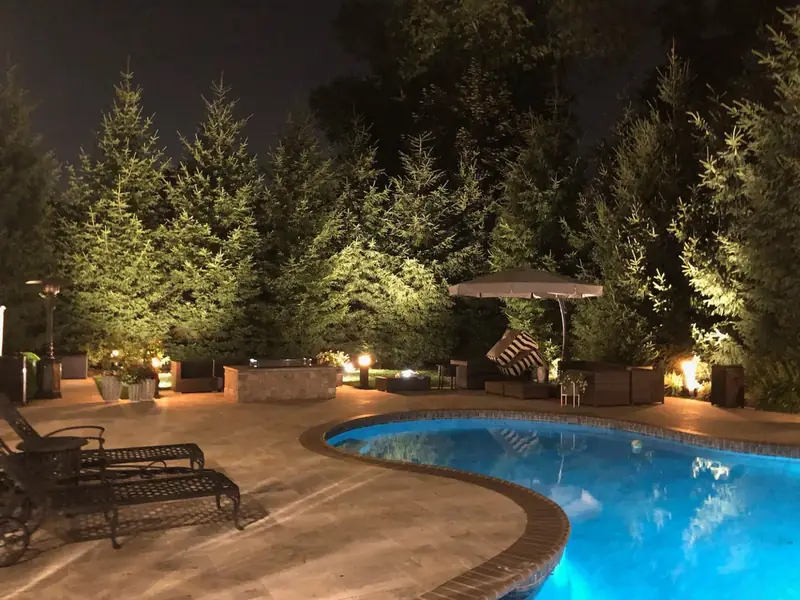 Outdoor Pool, Cresskill, NJ: pool and patio lighting with uplit evergreens