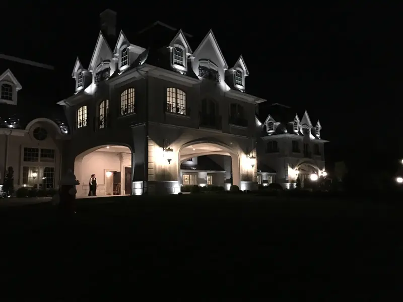 Residential Exterior, New Jersey: turreted home facade lit warmly at night