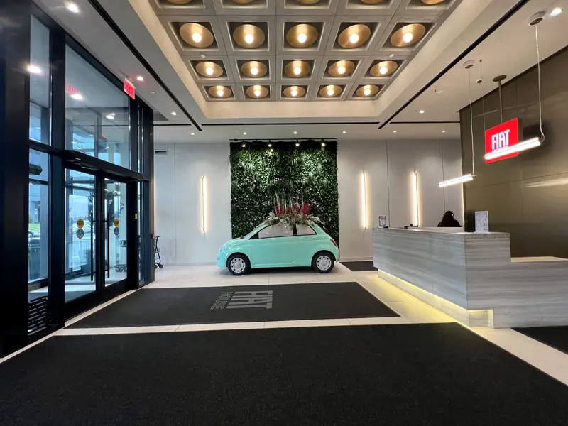 FIAT House Lobby, Fort Lee, NJ: apartment lobby with a gold-dome coffered ceiling, linear wall sconces, a green living wall and a reception desk with a lit toe-kick